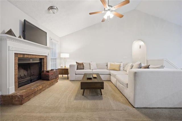 living room featuring a ceiling fan, carpet, high vaulted ceiling, arched walkways, and a fireplace