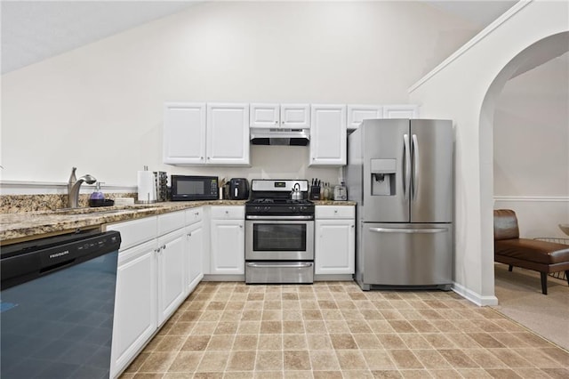 kitchen with under cabinet range hood, a sink, arched walkways, stainless steel appliances, and white cabinets