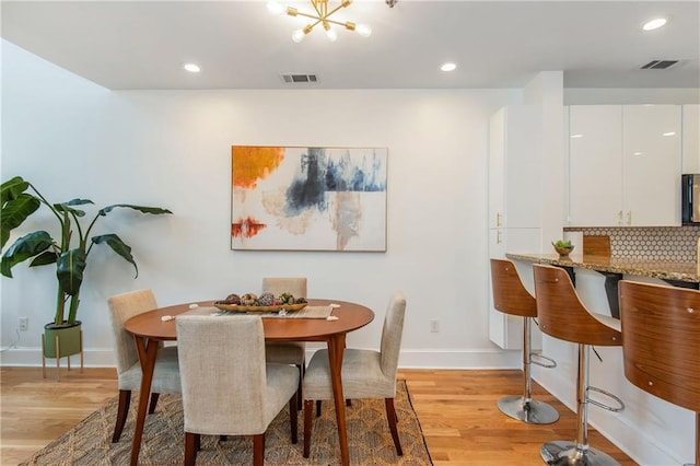 dining room featuring baseboards, visible vents, and light wood-style flooring