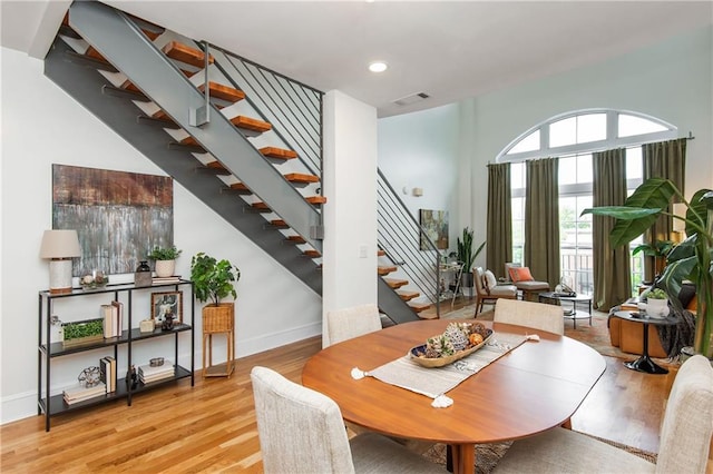 dining room featuring recessed lighting, baseboards, stairway, and light wood-type flooring