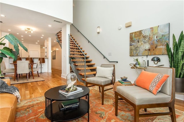 interior space with recessed lighting, baseboards, wood finished floors, visible vents, and stairway