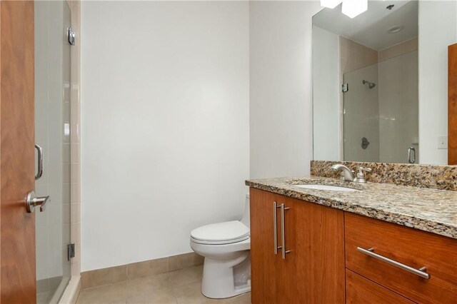 full bath featuring vanity, tile patterned floors, a stall shower, and toilet