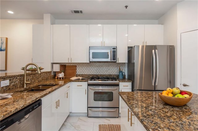 kitchen featuring visible vents, marble finish floor, dark stone counters, a sink, and appliances with stainless steel finishes