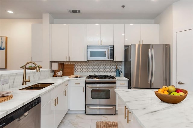 kitchen with visible vents, marble finish floor, white cabinetry, a sink, and appliances with stainless steel finishes