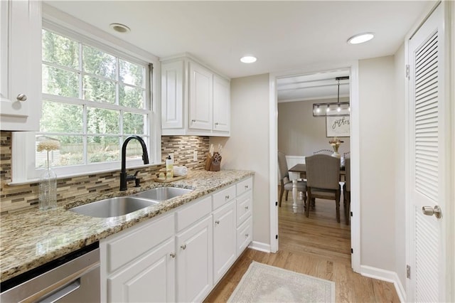 3719 Northbrook Ct, Atlanta, GA 30340 - kitchen with dishwasher, a sink, light wood-type flooring, baseboards, and backsplash