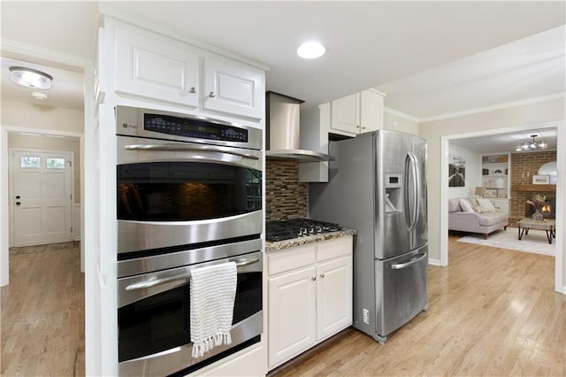 3719 Northbrook Ct, Atlanta, GA 30340 - kitchen with stainless steel appliances, wall chimney range hood, white cabinets, ornamental molding, and light wood-style flooring