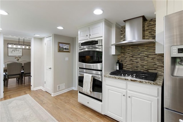 3719 Northbrook Ct, Atlanta, GA 30340 - kitchen with appliances with stainless steel finishes, wall chimney range hood, tasteful backsplash, light wood-style flooring, and light stone countertops