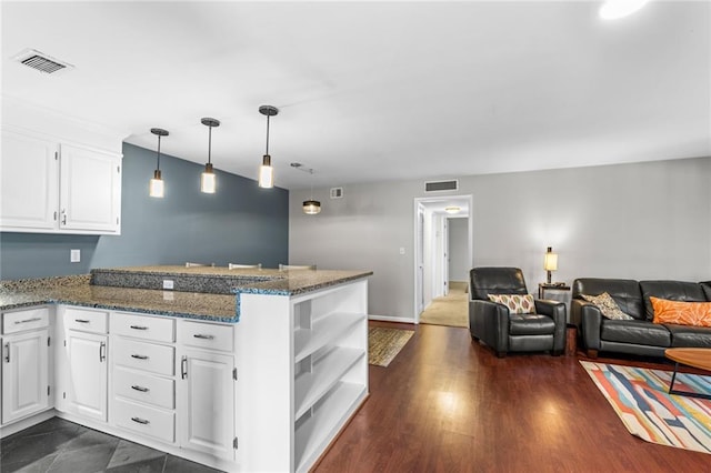 kitchen with kitchen peninsula, pendant lighting, dark hardwood / wood-style floors, and white cabinetry