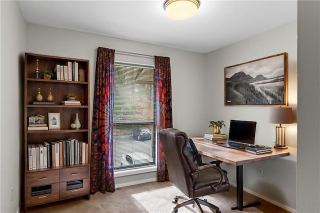 carpeted home office featuring baseboards