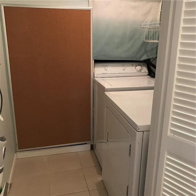 laundry area with laundry area, light tile patterned flooring, and washing machine and clothes dryer