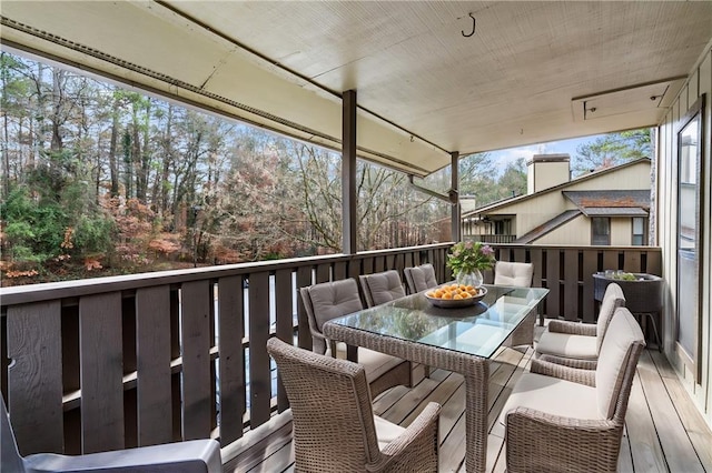 view of wooden balcony featuring outdoor dining space and a wooden deck