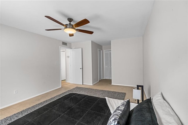 unfurnished bedroom featuring carpet flooring, ceiling fan, visible vents, and baseboards