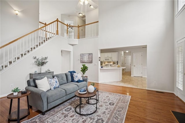 130 White Sands Ct, Suwanee, GA 30024 - living area featuring a high ceiling, ceiling fan, stairway, and light wood-style floors