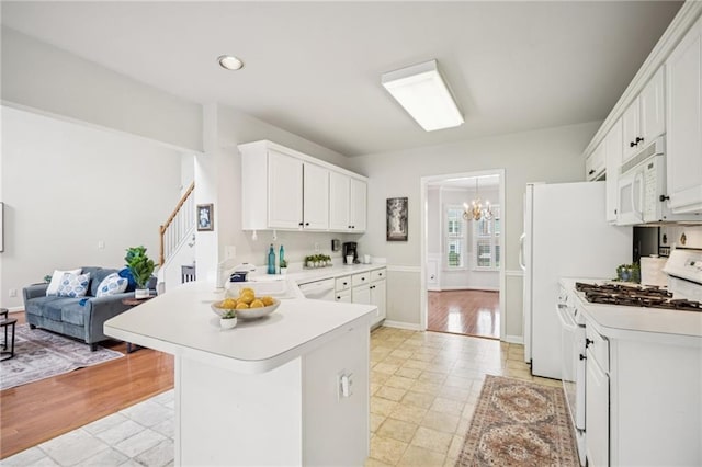 130 White Sands Ct, Suwanee, GA 30024 - kitchen with white appliances, a chandelier, light countertops, a peninsula, and recessed lighting