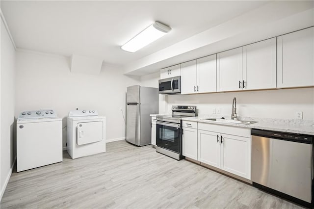 130 White Sands Ct, Suwanee, GA 30024 - kitchen featuring appliances with stainless steel finishes, washer and clothes dryer, light wood finished floors, white cabinetry, and light stone counters