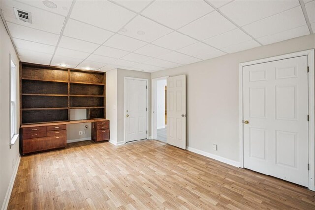 130 White Sands Ct, Suwanee, GA 30024 - unfurnished living room featuring light wood-type flooring, a drop ceiling, and built in shelves