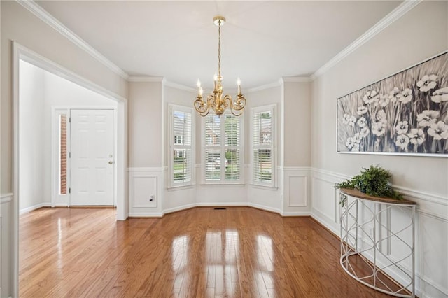 130 White Sands Ct, Suwanee, GA 30024 - unfurnished dining area with a chandelier, wood finished floors, a wainscoted wall, and ornamental molding