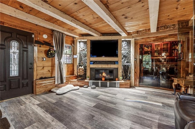 living room with wooden ceiling, wood walls, a fireplace, and beam ceiling