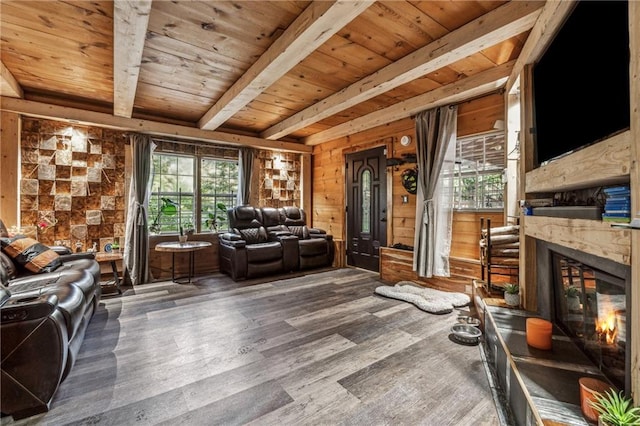 living room featuring a premium fireplace, wood walls, wood finished floors, wooden ceiling, and beamed ceiling