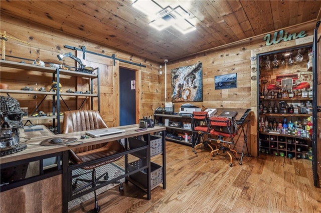 office space with wood ceiling, wooden walls, wood finished floors, and a barn door