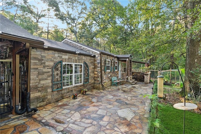 view of side of property featuring a patio area and stone siding