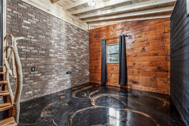 empty room featuring brick wall, beam ceiling, stairway, and wood ceiling