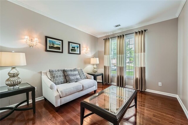 living area featuring dark wood finished floors, crown molding, baseboards, a brick fireplace, and ceiling fan