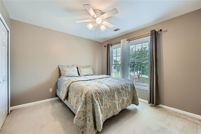 bedroom with decorative columns, crown molding, light colored carpet, and baseboards