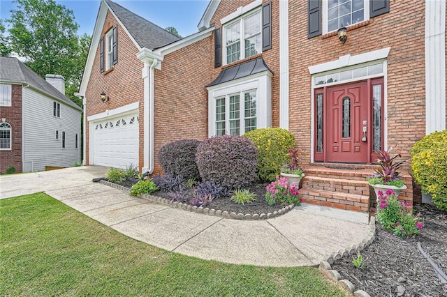 colonial inspired home with concrete driveway, brick siding, a front lawn, and an attached garage