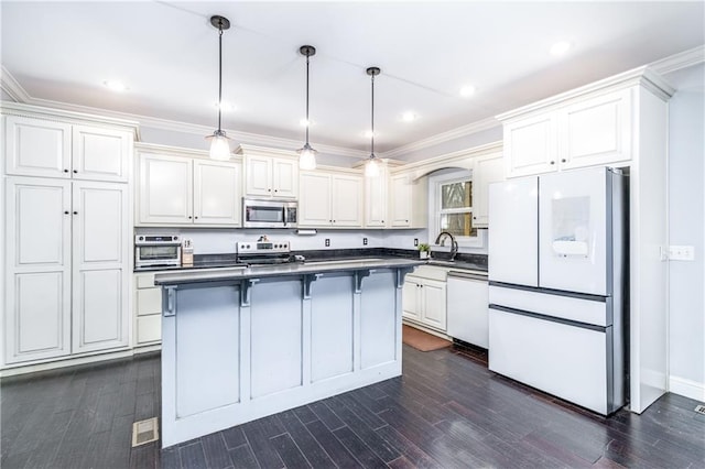 kitchen featuring hanging light fixtures, white cabinetry, appliances with stainless steel finishes, and dark wood-type flooring