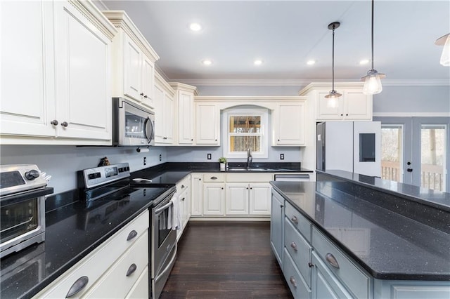 kitchen featuring appliances with stainless steel finishes, pendant lighting, sink, dark stone counters, and ornamental molding