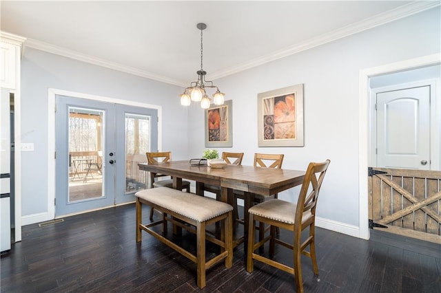 dining area featuring french doors, a notable chandelier, dark hardwood / wood-style flooring, and crown molding