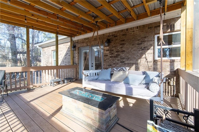 wooden deck featuring an outdoor living space with a fire pit