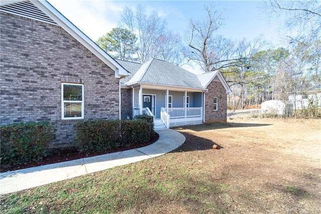 view of front of property with a porch and a front lawn