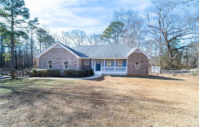 ranch-style home featuring a porch and a front yard