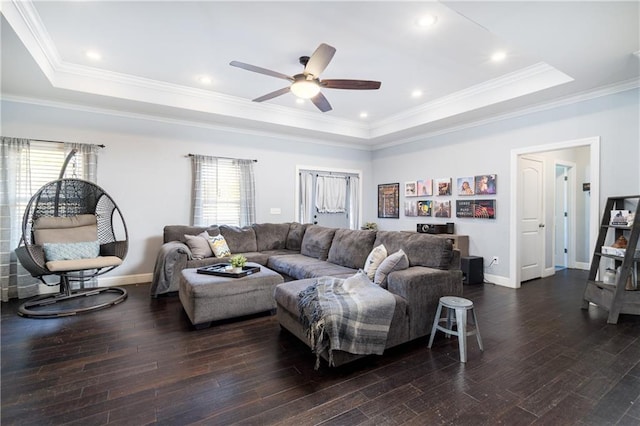 living room featuring dark wood-type flooring, ceiling fan, crown molding, and a raised ceiling