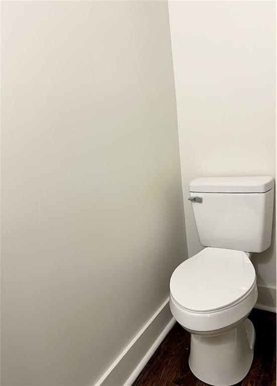 bathroom with hardwood / wood-style flooring and toilet