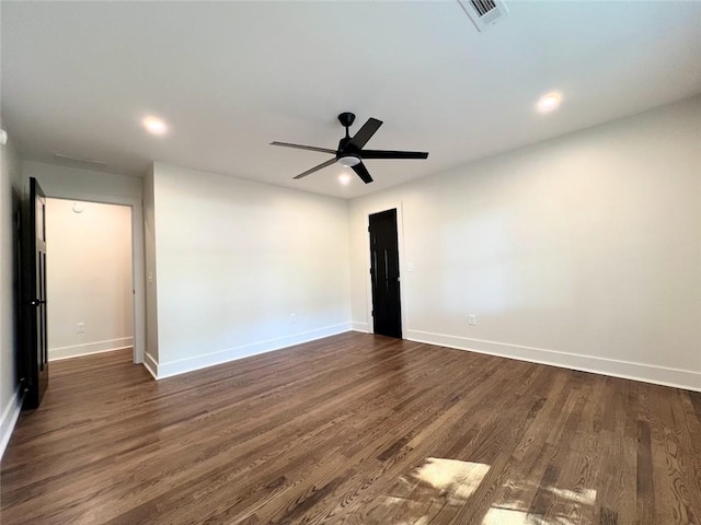 spare room with dark wood-type flooring and ceiling fan