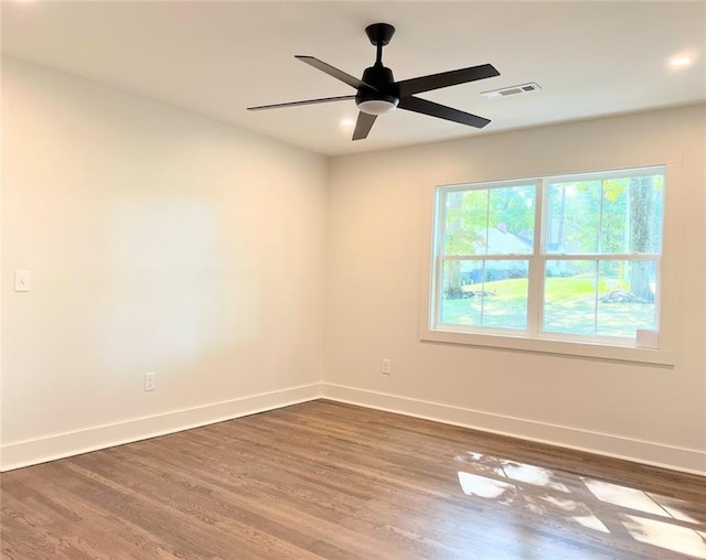 spare room featuring dark wood-type flooring and ceiling fan