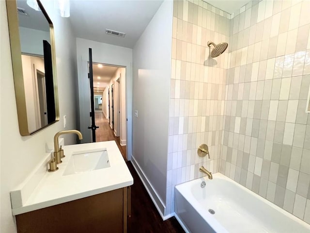 bathroom with vanity and tiled shower / bath combo