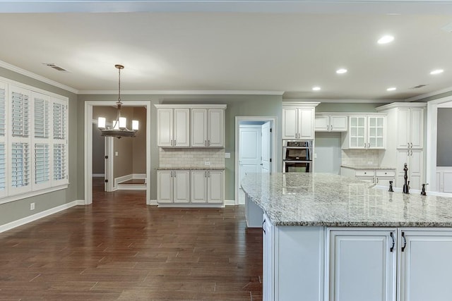 kitchen with white cabinetry, a notable chandelier, visible vents, and ornamental molding