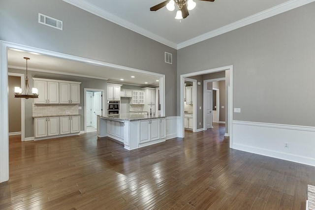 kitchen with dark wood finished floors, visible vents, backsplash, and ceiling fan