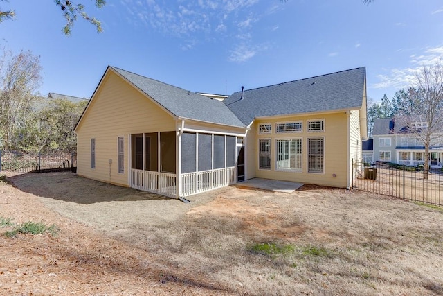 rear view of house with a shingled roof, fence, and a sunroom