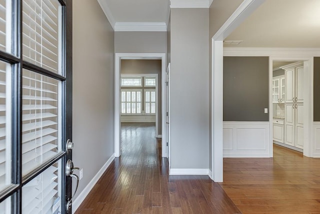 foyer featuring dark wood-style floors, visible vents, ornamental molding, wainscoting, and a decorative wall