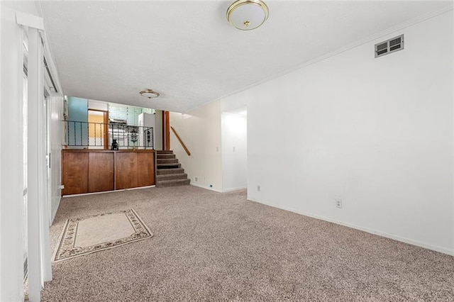 2117 Chestnut Hill Cir, Decatur, GA 30032 - unfurnished living room featuring carpet floors, stairs, ornamental molding, and a textured ceiling