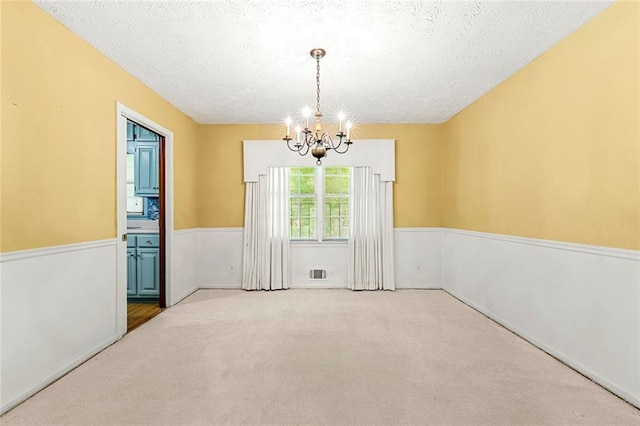 2117 Chestnut Hill Cir, Decatur, GA 30032 - carpeted empty room with a chandelier, a textured ceiling, and a wainscoted wall