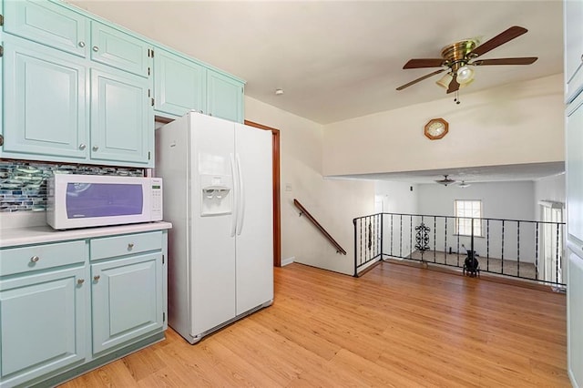 2117 Chestnut Hill Cir, Decatur, GA 30032 - kitchen with white appliances, ceiling fan, blue cabinets, light wood-type flooring, and tasteful backsplash