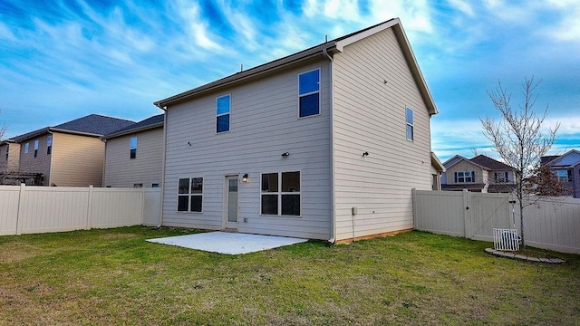 back of property featuring a yard, a patio area, a fenced backyard, and a gate