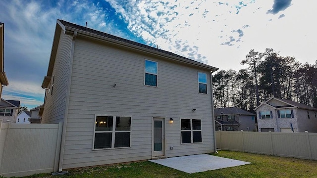 back of house with a fenced backyard, a patio, and a lawn