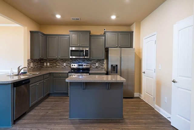 kitchen with gray cabinetry, a sink, visible vents, appliances with stainless steel finishes, and decorative backsplash